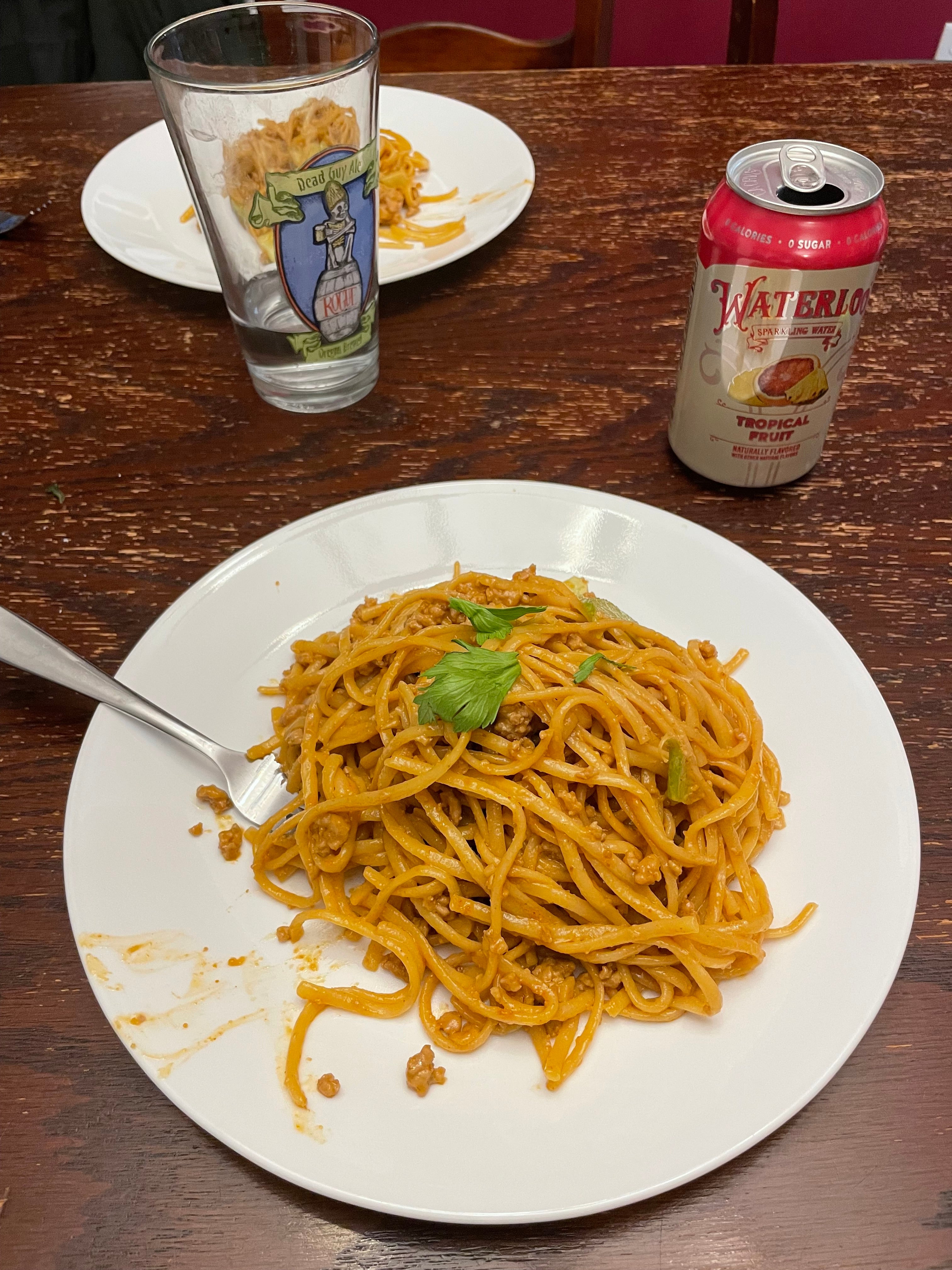 Noodles in a peanut sauce on a white plate