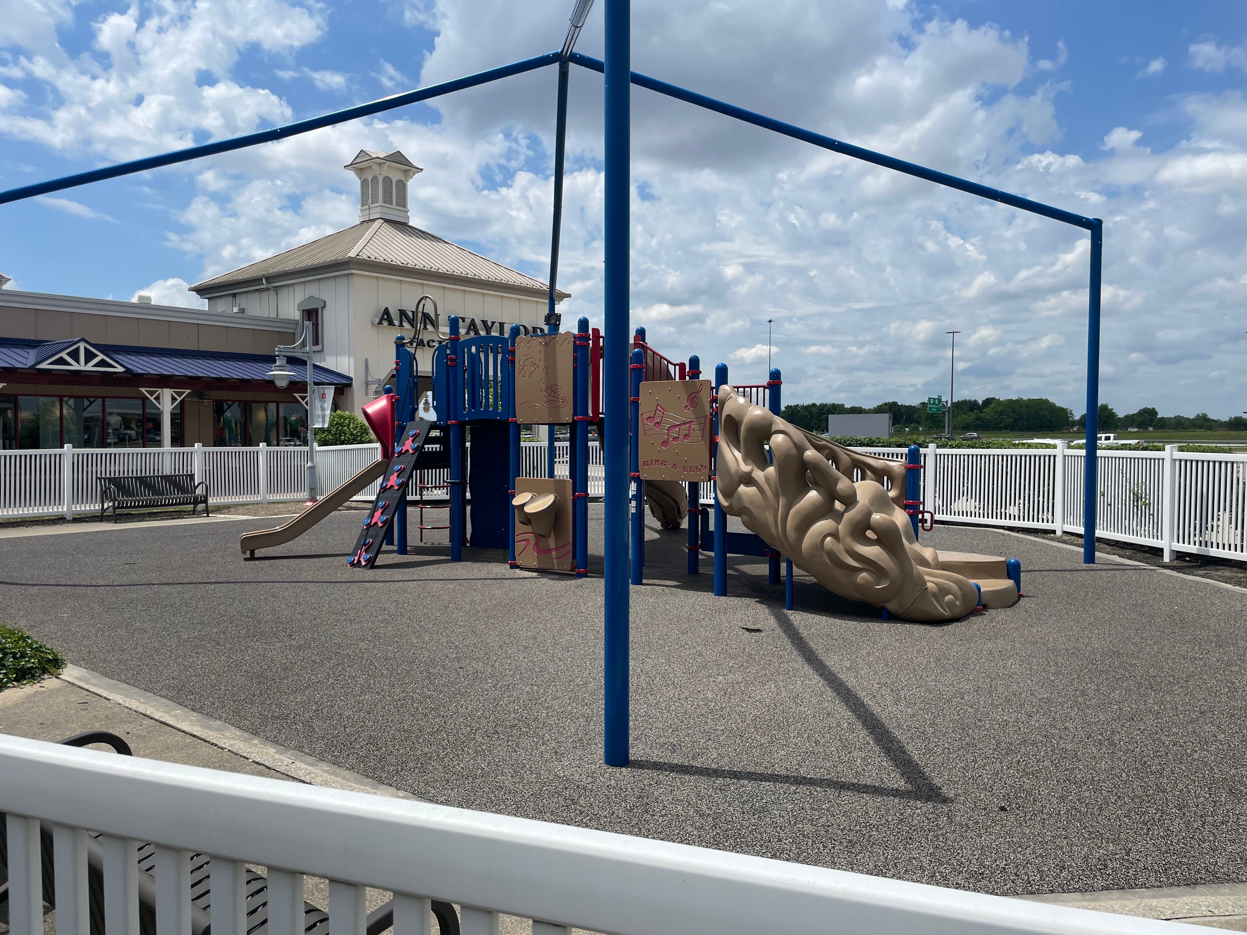 a playground with plastic/rubber ground, plastic and metal equipment. not a tree in sight, no cover from the blazing sun.